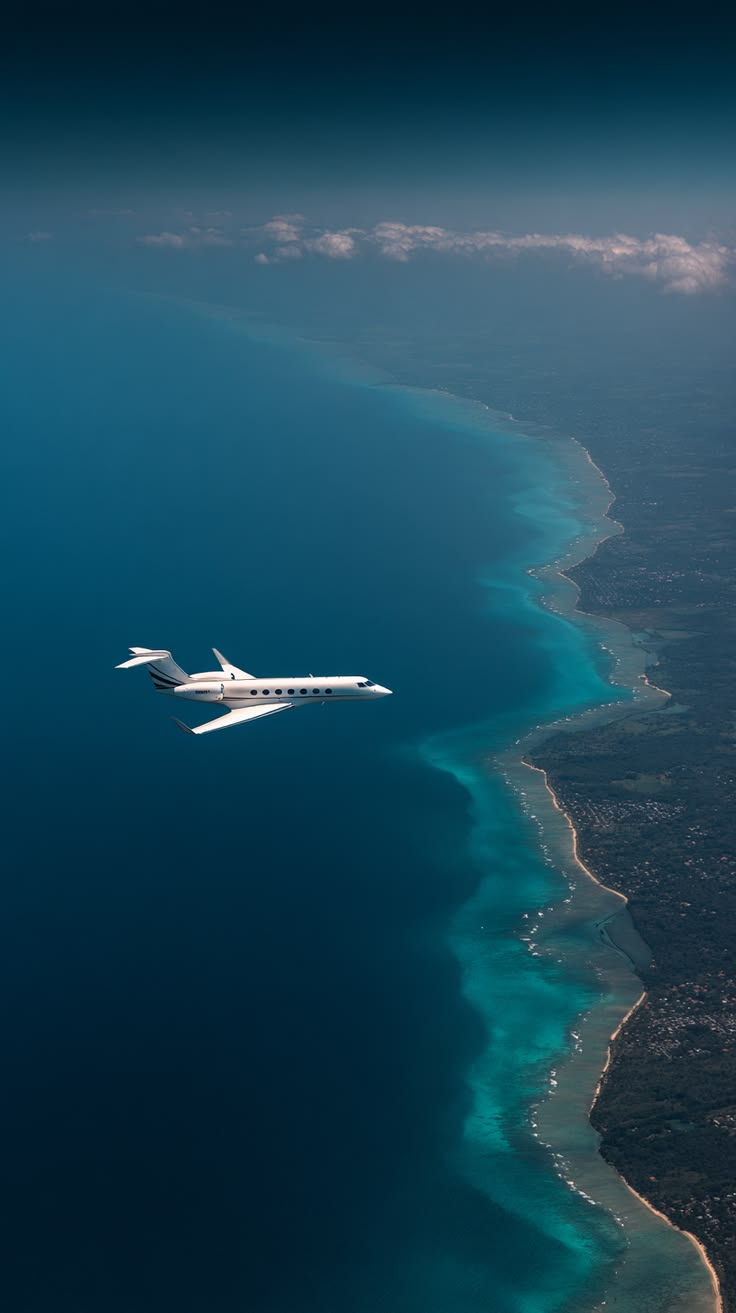 Private jet flying high above a tropical coastline